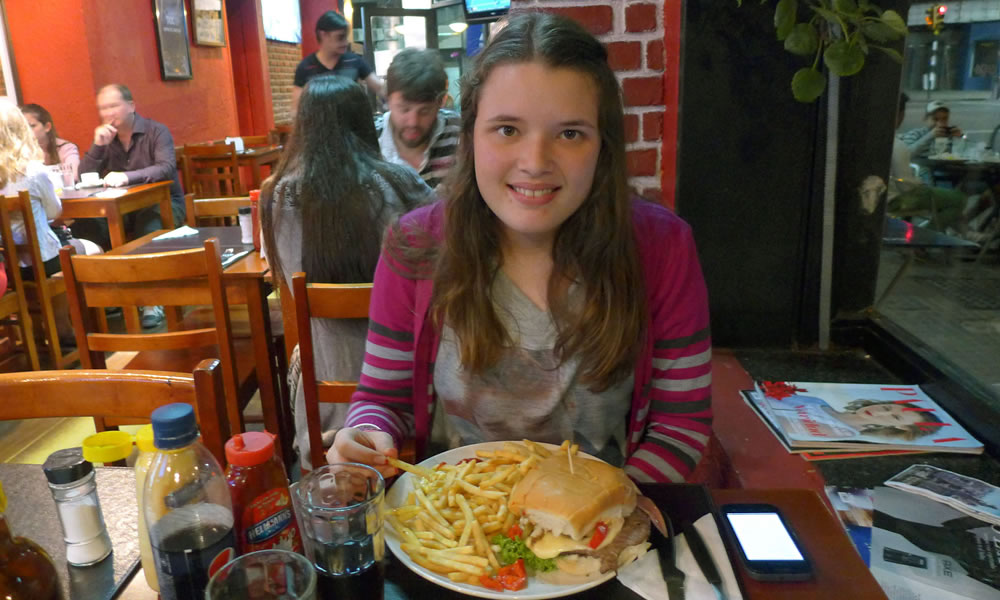 Una joven se apresta a degustar un chivito en un restaurante de Montevideo (Uruguay). Foto: EFE