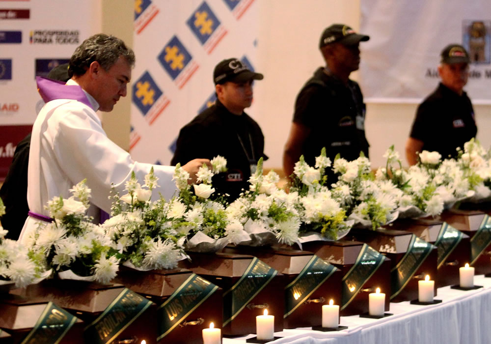 Un sacerdote bendice los restos óseos de 27 personas desaparecidas en los departamentos de Antioquia, Magdalena y Chocó. Foto: EFE