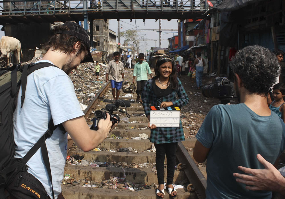 La filmación en el slum de Garib Nagar en las vías en Bombay, para el rodaje del documental "La alfombra roja", que narra la vida de la niña Rubina Alí. Foto: EFE