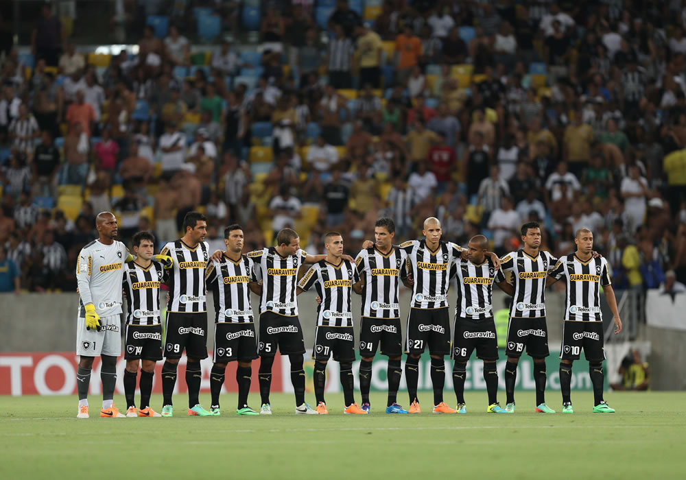 Los jugadores de Botafogo se alinean durante un minuto de silencio en homenaje al camarógrafo Santiago Andreade antes del partido por la Copa Libertadores. Foto: EFE