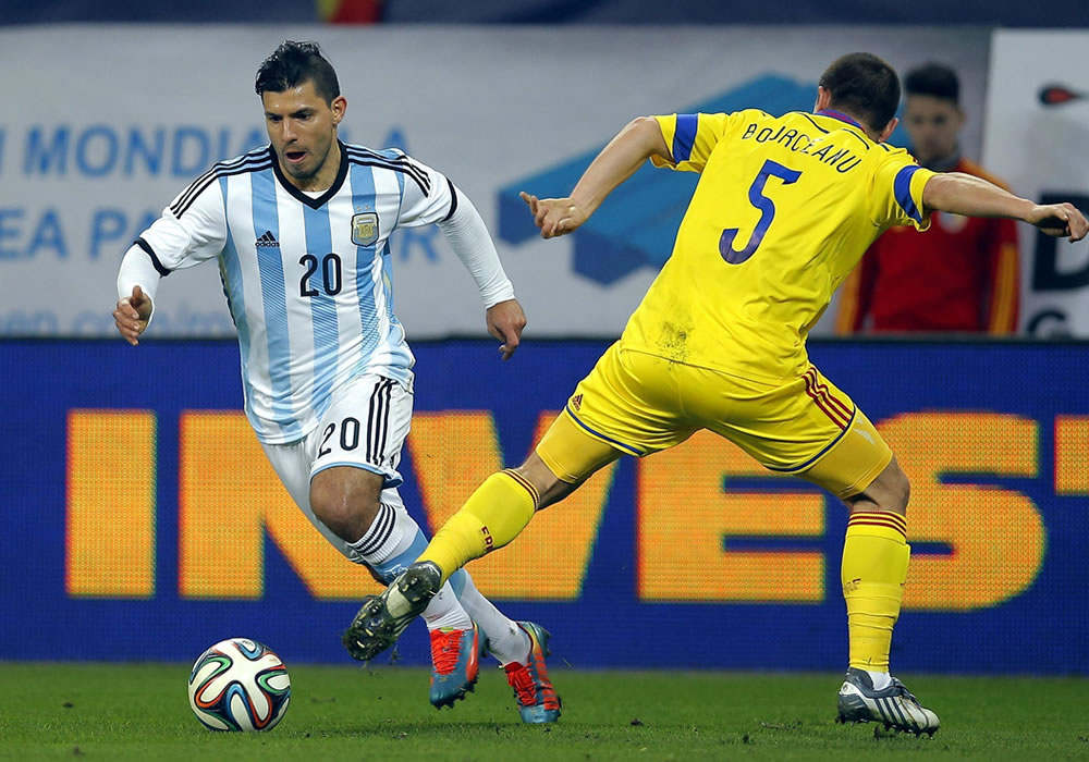 El delantero de la selección argentina, Sergio 'Kun' Agüero (i) lucha por el balón con Alexandru Bourceanu (d) de Rumanía. Foto: EFE