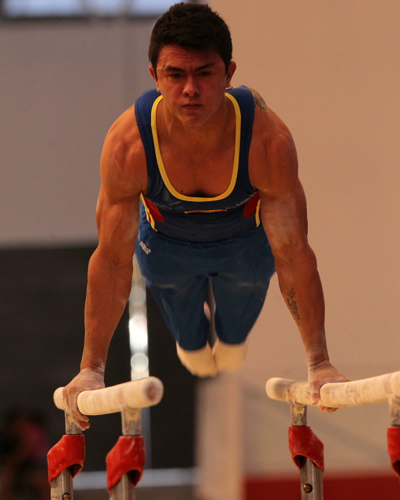 El gimnasta colombiano Jossimar Calvo compite en la prueba barras paralelas en la categoría gimnasia masculina. Foto: EFE