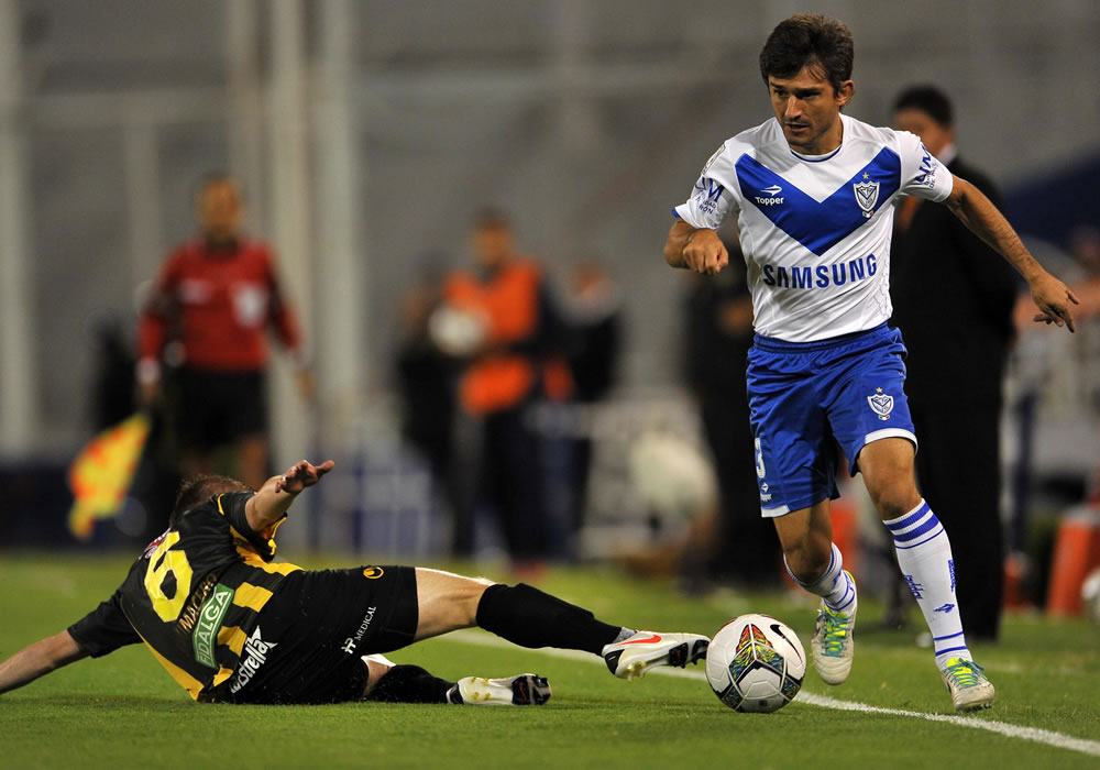 El jugador de Vélez Emiliano Papa disputa el balón con Saúl Chumacero de The Strongest. Foto: EFE