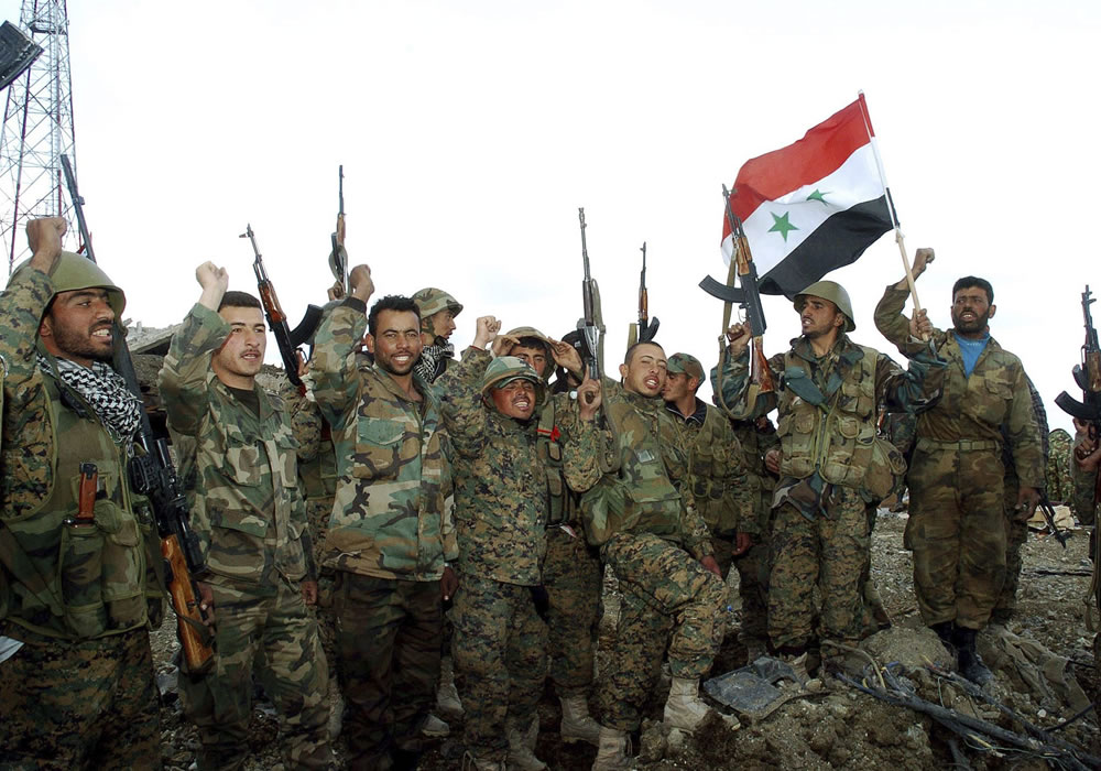 Fotografía cedida por la Agencia Siria de Noticias SANA que muestra a soldados sirios celebrando el fin de la ofensiva rebelde en la provincia de Lattakia. Foto: EFE