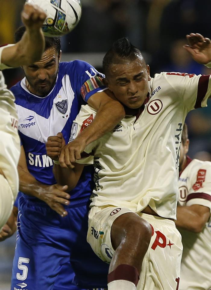 El jugador de Vélez Sarsfield Fabián Cubero (i) y disputa el balón con Néstor Duarte (d), de Universitario. Foto: EFE
