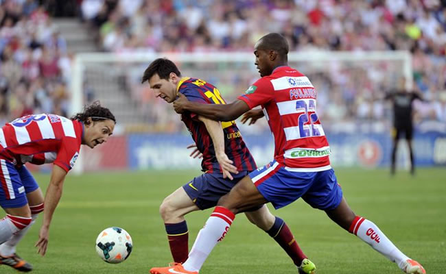 El delantero argentino del FC Barcelona Leo Messi (c) trata de escapar entre Iturra (i) y el francés Foulquier, ambos del Granada. Foto: EFE