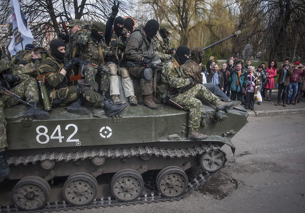 Prorrusos armados y vestidos con trajes militares avanza en un tanque por una calle de Sláviansk, en la región de Donetsk (Ucrania). Foto: EFE