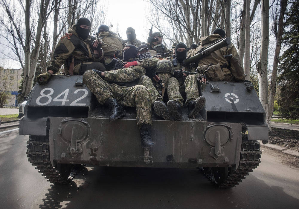 Un tanque con prorrusos armados y vestidos con trajes militares avanza por una calle de Sláviansk, en la región de Donetsk (Ucrania). Foto: EFE