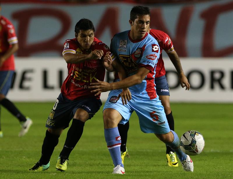 El jugador de Arsenal de Argentina Gastón Esmerado (d) disputa un balón con Cristian Manuel Chavez (i) de Unión Española. Foto: EFE