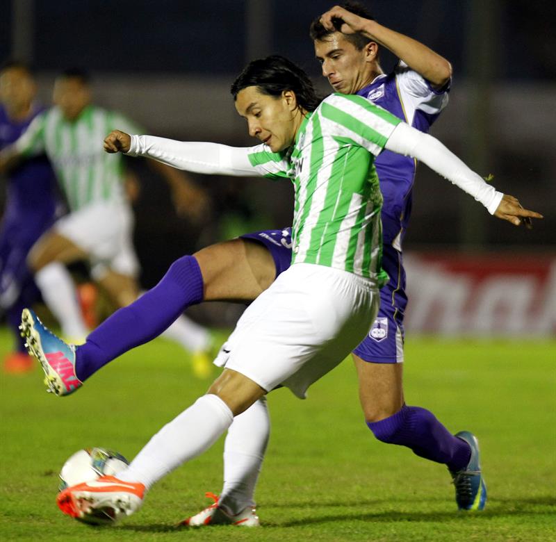 El jugador de Atlético Nacional Sherman Cárdenas (adelante) patea el balón ante la marca de Leonardo Pais (atrás), del Defensor Sporting. Foto: EFE