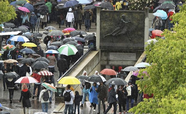 Espectadores esperan a que la lluvia amaine durante el torneo de Roland Garros. Foto: EFE
