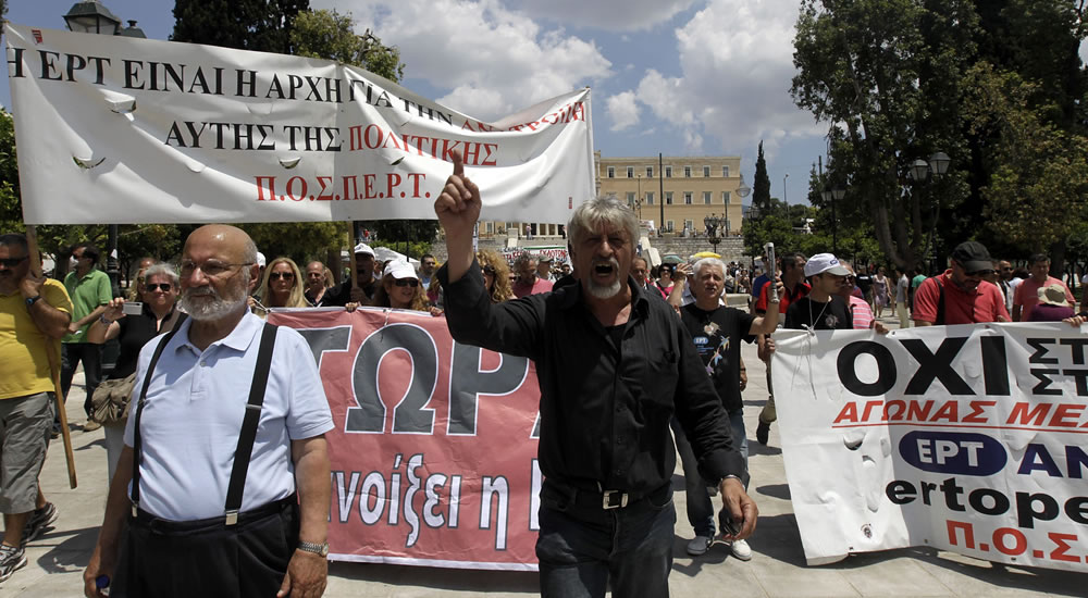 Periodistas en huelga gritan eslóganes mientras marchan delante del edificio del Parlamento en Atenas. Foto: EFE