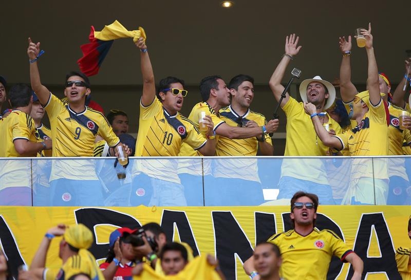Aficionados colombianos animan a su equipo durante el partido Colombia-Costa de Marfil, del Grupo C. Foto: EFE