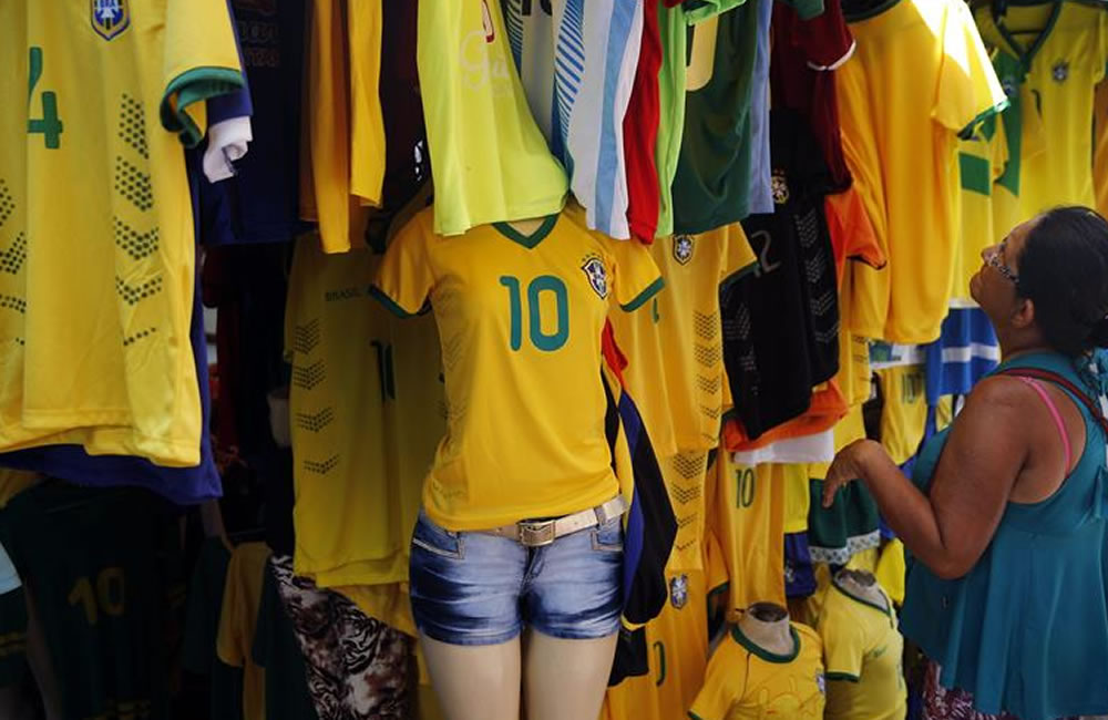 Una mujer observa varias camisetas de la selección brasileña exhibidas. Foto: EFE