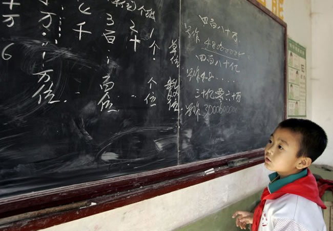 Niño chino en la pizarra, estudiando matemáticas. Foto: EFE