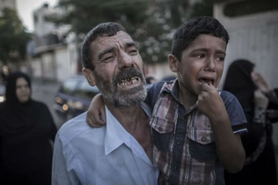 El padre y el hermano de dos de los niños asesinados en un bombardeo de la flota israelí en el puerto de Gaza. Foto: EFE