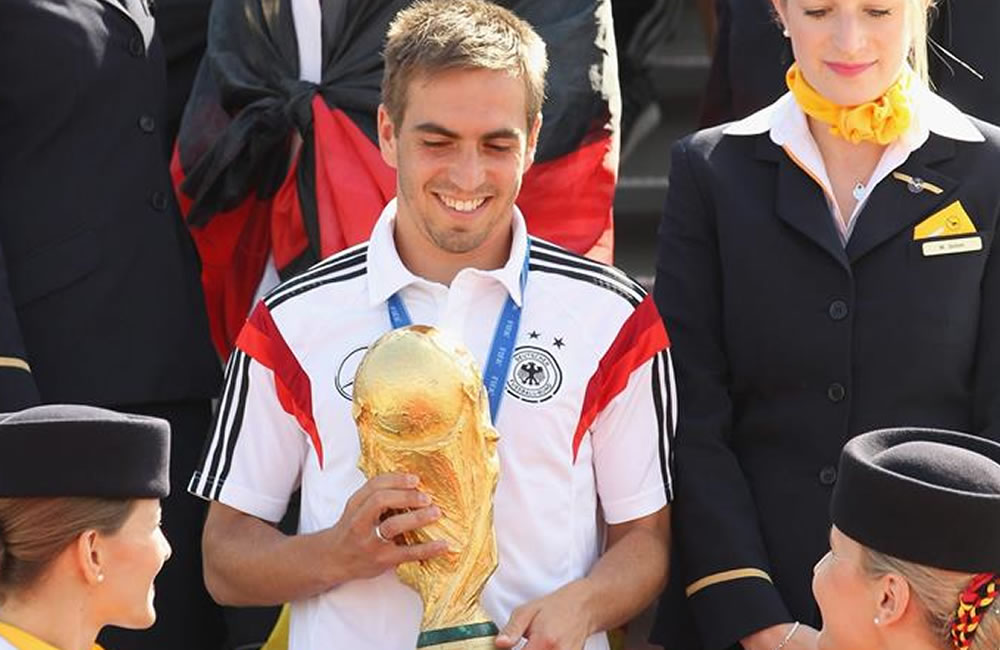 El capitán de la selección alemana de fútbol, Philipp Lahm (c), desciende del avión con la Copa del Mundo de la FIFA. Foto: EFE