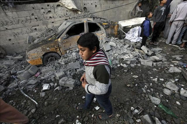 Niños palestinos inspeccionan los restos de casas destruidas tras un ataque aéreo israelí sobre territorio de Gaza. (). Foto: EFE