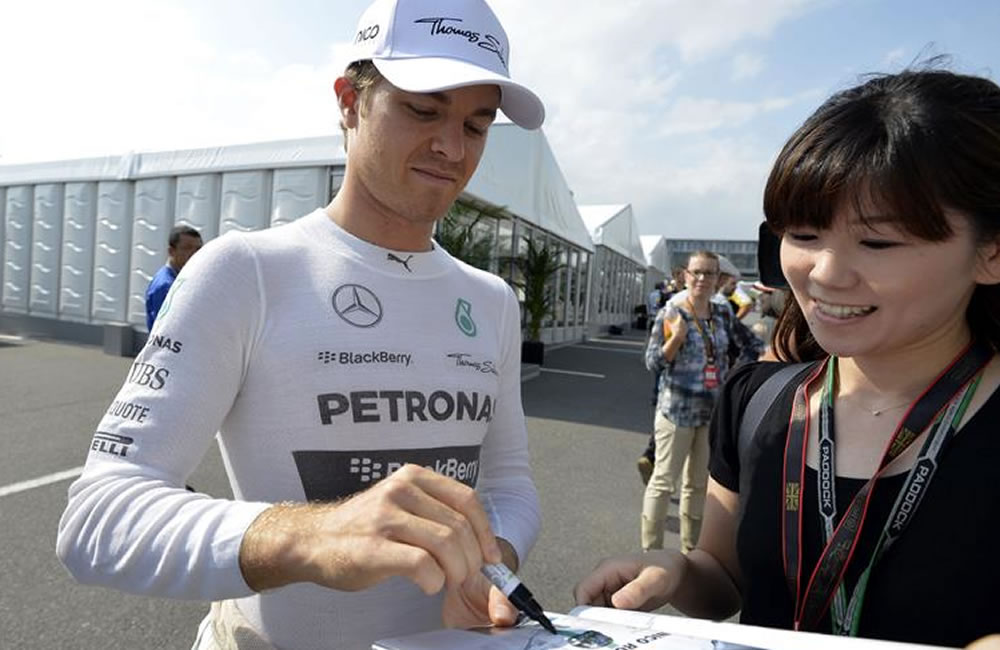 El piloto alemán de Fórmula Uno Nico Rosberg, de Mercedes, firma autógrafos antes de la segunda sesión de entrenamientos libres. Foto: EFE
