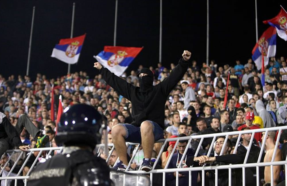 Policías vigilan a hinchas serbios en medio de una pelea durante el partido clasificatorio de la Eurocopa 2016. Foto: EFE