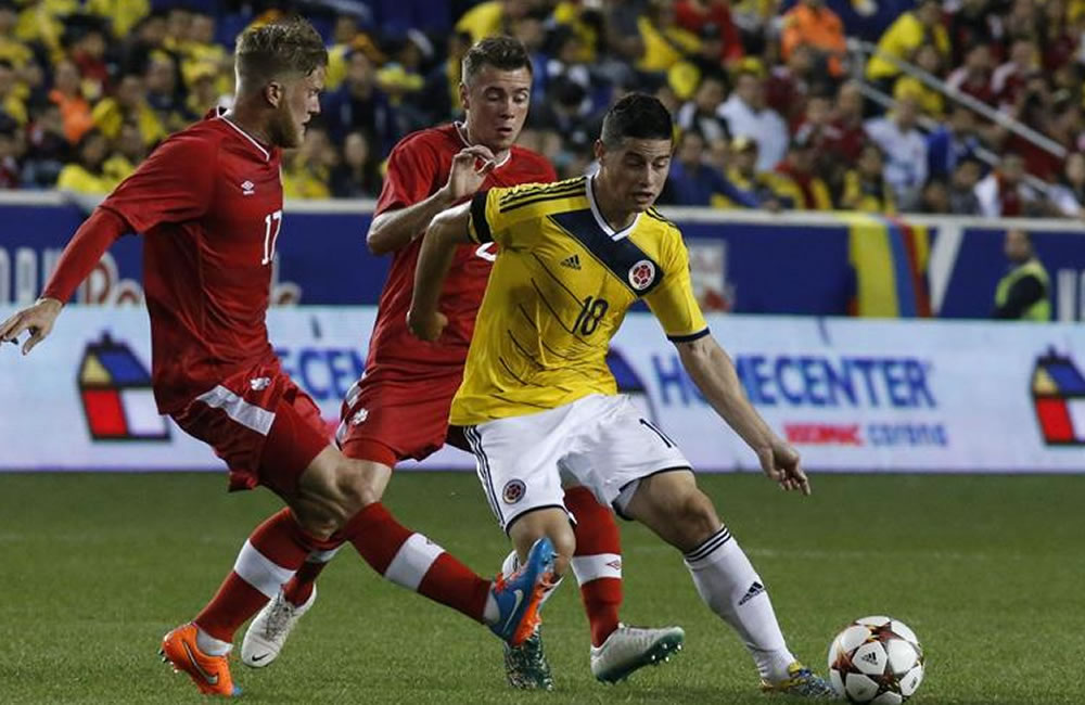 El jugador del la selección Colombia James Rodríguez (d) disputa el balón con Marcel Dejong (i) de Canadá. Foto: EFE