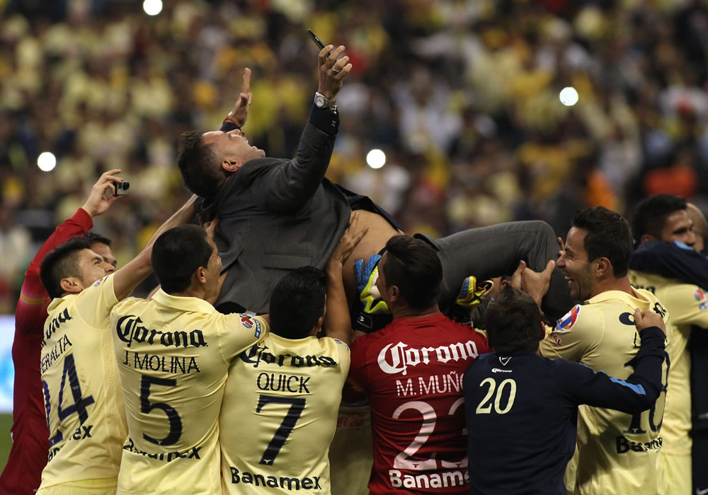Jugadores de América celebran el campeonato al derrotar a Tigres por 3-0, junto a su entrenador Antonio Mohamed (arriba). Foto: EFE