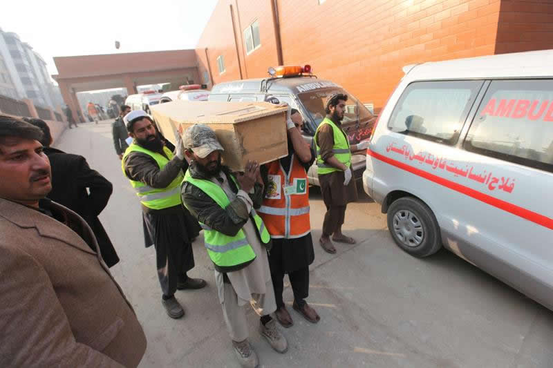 Miembros de los servicios de rescate trasladan el cadáver de una de las víctimas del ataque talibán a Colegio de Pakistán. Foto: EFE