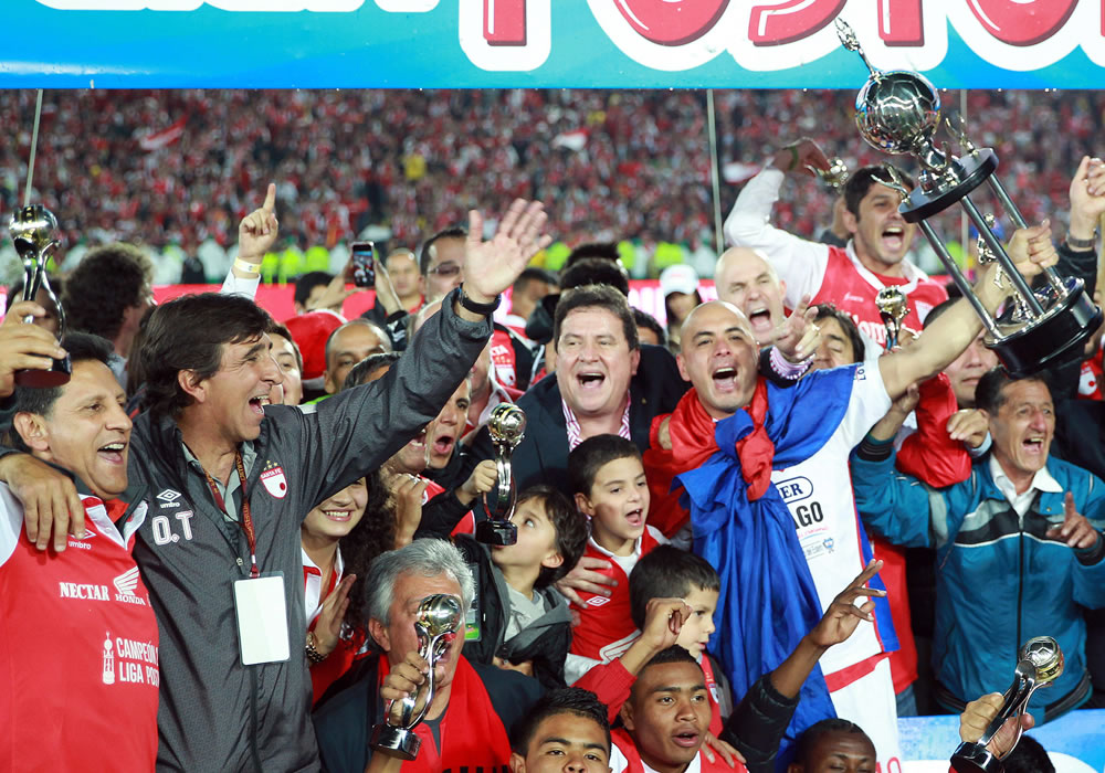 El director técnico de Santa Fe Gustavo Costas (2i) y Omar Pérez (d) celebran con la copa luego de vencer a Medellín. Foto: EFE