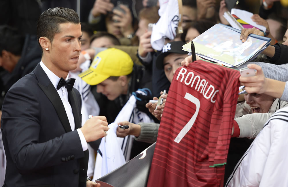 -El jugador portugués Cristiano Ronaldo (i) firma autógrafos. Foto: EFE