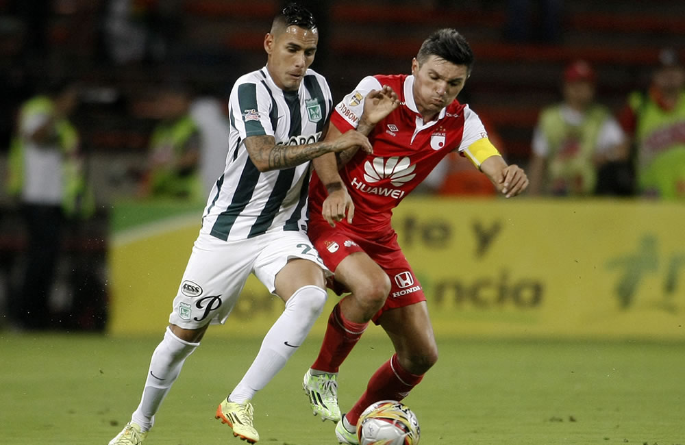 El jugador de Atlético Nacional Gilberto Garcia (i) disputa el balón con el jugador de Independiente Santa Fe. Foto: EFE
