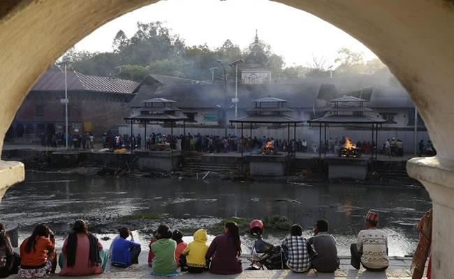 Varias personas asisten a la incineración de una de las víctimas del seísmo que ha sacudido a Nepal. Foto: EFE