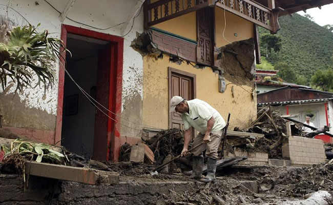Un hombre limpia una de las casas afectadas por la quebrada Liboriana en Salgar, Antioquia. Foto: EFE