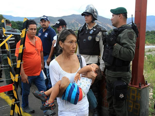 Colombianos regresan a su país desde Venezuela a través de un filtro impuesto por la guardia venezolana. Foto: EFE