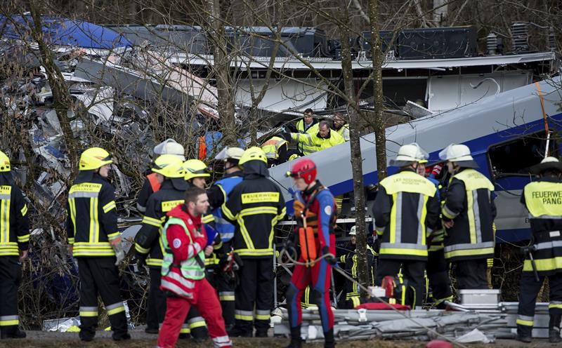 Bomberos y miembros de los servicios de emergencia trabajan en el lugar donde se ha producido el choque de dos trenes en Bad Aibling (Alemania). Foto: EFE