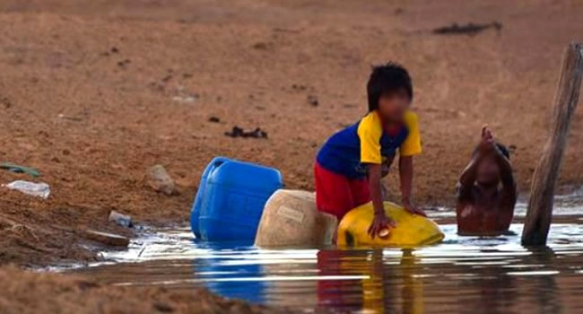 Niños sacando agua de un foso en la Guajira. Foto: EFE