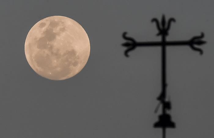 Vista de una luna llena que se levanta al anochecer, en Cali, Colombia. Foto: AFP