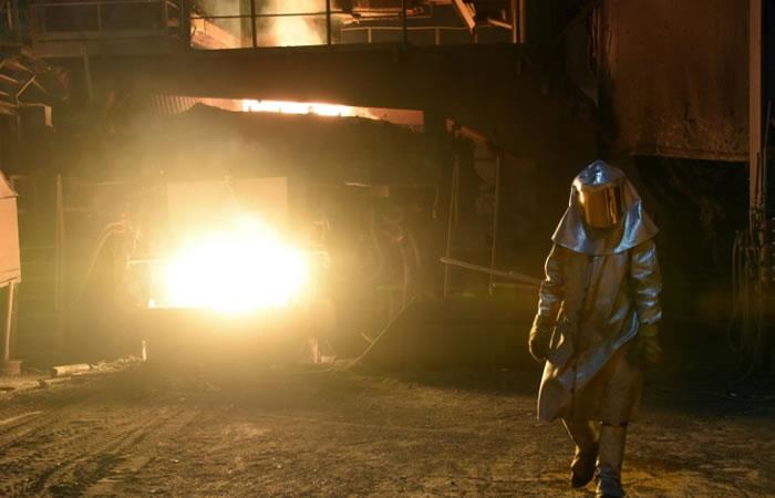 Un trabajador con traje protector comprueba la temperatura del acero fundido en un alto horno de una fábrica de Koppel. Foto: AFP