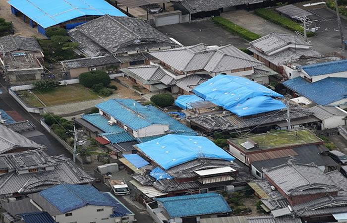 Los techos de algunas casas han sido tapados con sábanas azules. Foto: AFP