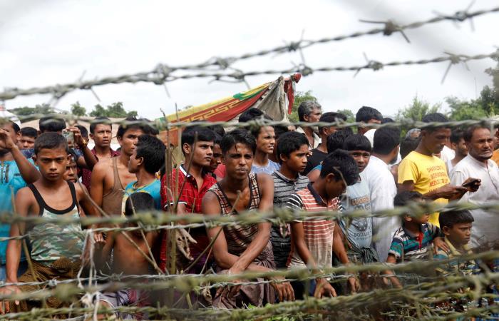 Rohinyás esperan junto a una valla en la frontera entre Bangladesh y Birmania, en el distrito de Maungdaw, Birmania. Foto: EFE
