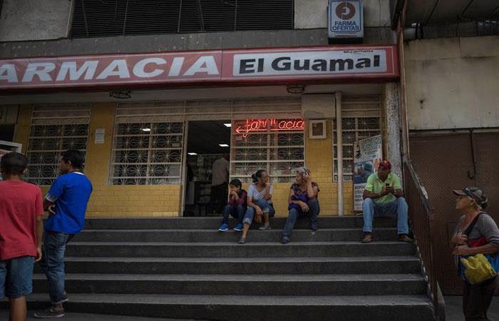 Un grupo de personas aguarda por transporte público mientras continúa el apagón en Venezuela. Foto: EFE