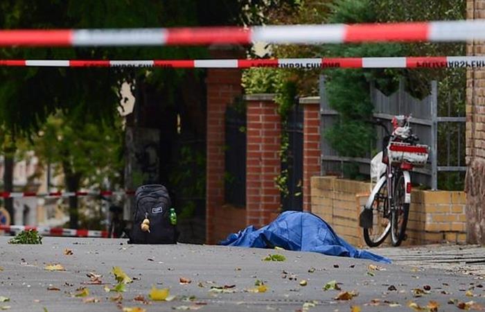 El cadáver de una persona baleada es cubierto con una manta azul cerca de una sinagoga, después de un tiroteo en Halle, Alemania. Foto: EFE
