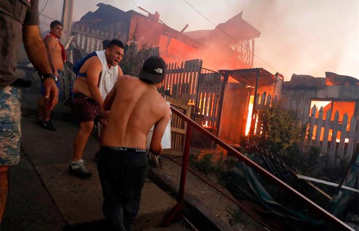 Varias personas intentaban apagar el fuego en Valparaíso. Foto: EFE