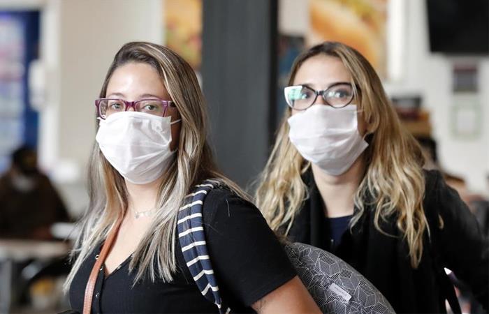 Turistas que llegan al aeropuerto El Dorado se protegen con tapabocas por el virus COVID-19. Foto: EFE