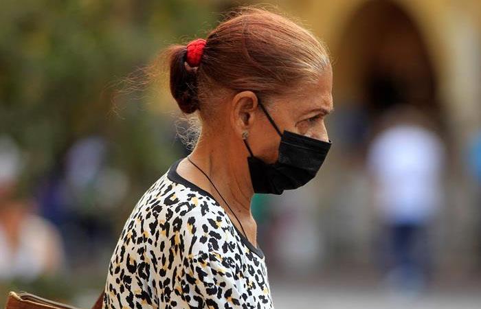 Mujer se protege del virus en Cartagena. Foto: EFE
