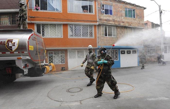 Soldados del Ejército desinfectan una zona al norte de Bogotá. Foto: EFE