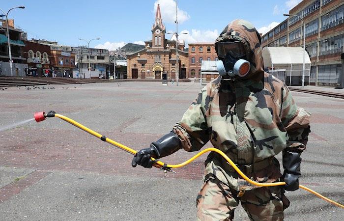 Uniformado del Ejército desinfecta un parque en el barrio 20 de julio, en Bogotá. (). Foto: EFE