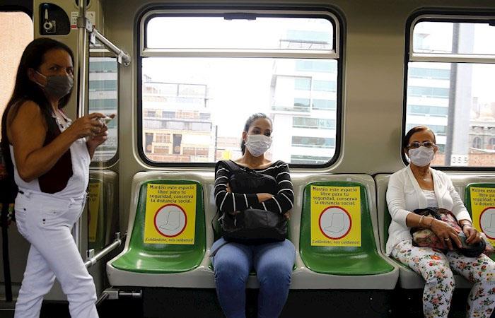 Mujeres se mueven con los protocolos de seguridad en el metro de Medellín. (). Foto: EFE