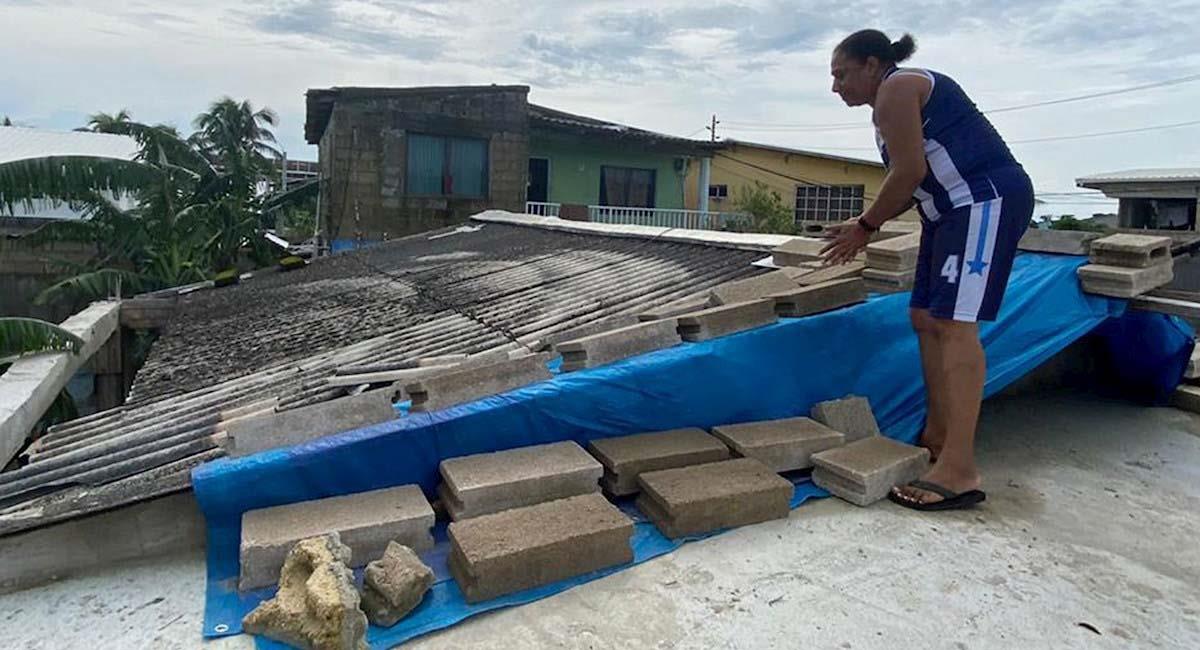 Una persona repara el techo de su casa en la isla de San Andrés, tras el paso de Iota. Foto: EFE