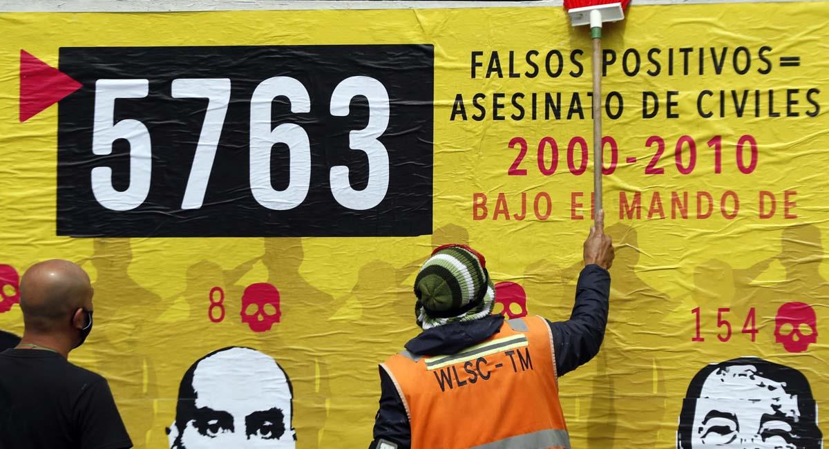 Personas participan en la elaboración de un mural sobre los falsos positivos, en Bogotá. Foto: EFE