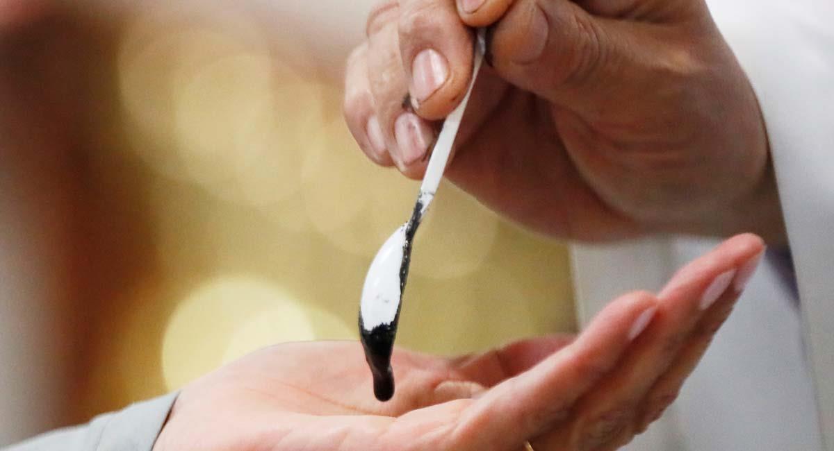 Un sacerdote entregaba cenizas en la mano a los fieles durante el pasado Miércoles de Ceniza. Foto: EFE